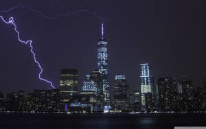 夜間紐約天際線，一道明亮的紫色閃電照亮天空。 — 閃電 壁紙