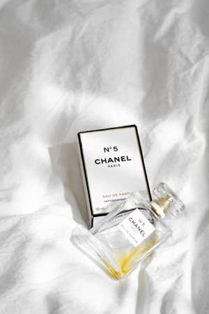 Chanel No 5 香水瓶和盒子放在白色布上，帶有柔和陰影。 — 香奈兒 壁紙