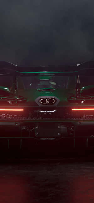 綠色McLaren Senna跑車後視圖，在黑暗煙霧環境中發出紅色光芒。 — 19.5:9 壁紙