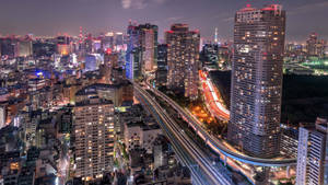 夜間城市景觀，有燈光建築物和車輛光跡。 — 東京鐵塔 壁紙