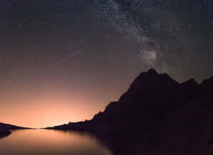 繁星點點的夜空，銀河橫跨山間湖泊，暮色中 — 宇宙 壁紙