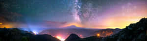 星空下的山脈，帶有發光的幾何圖案和遠處的燈光。 — 美學大理石 壁紙