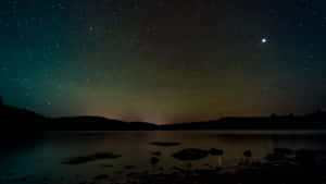繁星之夜，北極光映照平靜的湖面和黑暗的山丘。 — 黑夜 壁紙