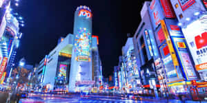 夜晚霓虹燈照亮城市街道，閃爍的招牌和建築物。 — 富士山 壁紙