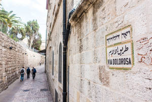 耶路撒冷一條狹窄的石巷，帶有苦路 Via Dolorosa 的多語標誌。 — 以色列 壁紙