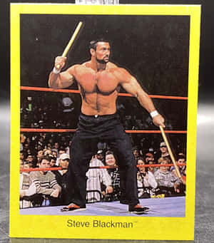 摔角手 Steve Blackman 在有觀眾的摔角擂台上手持木棍。 — 卡蒂 B 壁紙