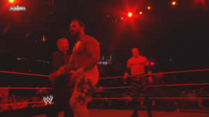 WWE摔角手在擂台上，處於紅色燈光下進行現場活動。 — 摔角 壁紙