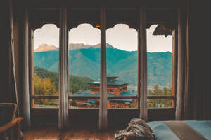 舒適的臥室，可欣賞日出時的山間寺廟 — 不丹 壁紙