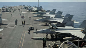 航空母艦甲板上的軍用飛機，船員正在工作。