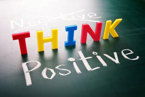 色彩繽紛的3D字母拼出THINK，放在黑板上，'Negative'被劃掉，下面寫著'Positive'。 — 桌面 壁紙