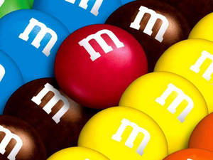 一堆帶有白色m標誌的色彩繽紛M&M's巧克力糖果。
