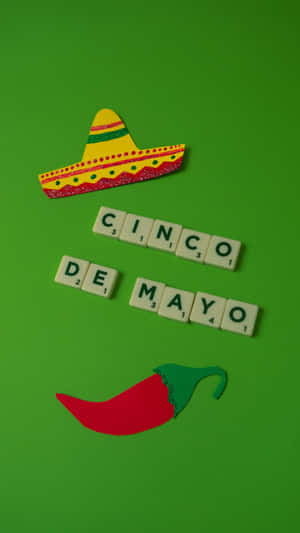 綠色背景上，用 Scrabble 字母牌拼出 Cinco de Mayo，並配上墨西哥闊邊帽和辣椒。 — 慶祝 壁紙