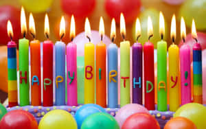 色彩繽紛的生日蠟燭拼出生日快樂，周圍有氣球。 — 生日 壁紙