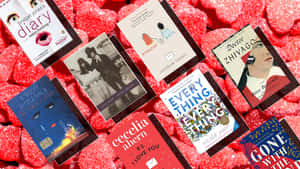 各種書本封面散落在紅色心形糖果上。 — 日蝕 壁紙