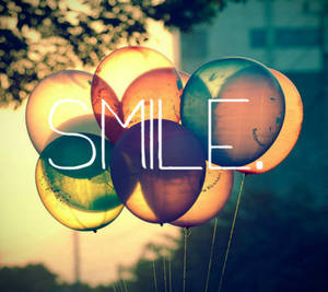 日落時飄浮的色彩繽紛氣球，疊加 SMILE 字樣。 — Tumblr 壁紙