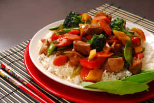 肉類蔬菜炒菜放在白飯上，用紅色盤子盛裝，附上筷子。 — 中文 壁紙