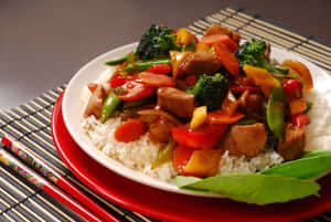 肉類蔬菜炒菜放在白飯上，用紅色盤子和筷子盛裝。 — 印度 壁紙