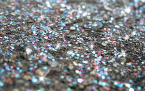色彩繽紛的閃粉在深色紋理地面上閃爍的特寫。 — 金色亮片 壁紙