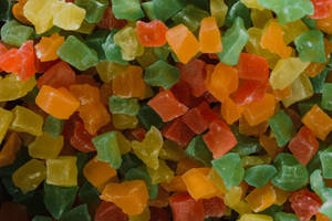 一堆色彩繽紛的蜜餞水果塊，有紅色、橙色、黃色和綠色。 — 甜食控 壁紙