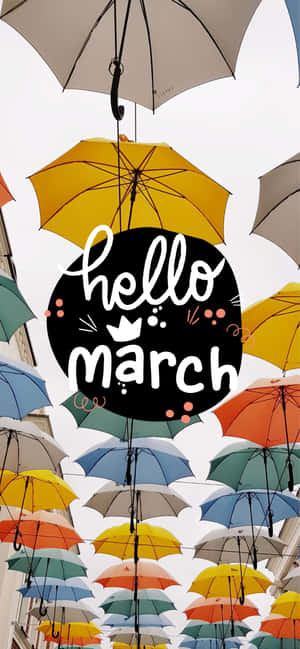 節日展示的懸掛彩色雨傘，帶有 hello march 標誌。 — iPhone 18 壁紙