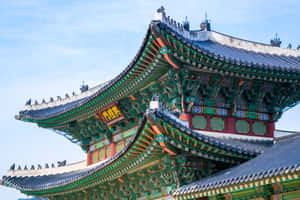 色彩鮮豔的傳統韓國寺廟屋頂，在藍天下帶有複雜細節。 — 南韓 壁紙