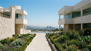 現代建築物配以石牆和花園，框出一條通往城市天際線的小徑。 — 洛杉磯 壁紙