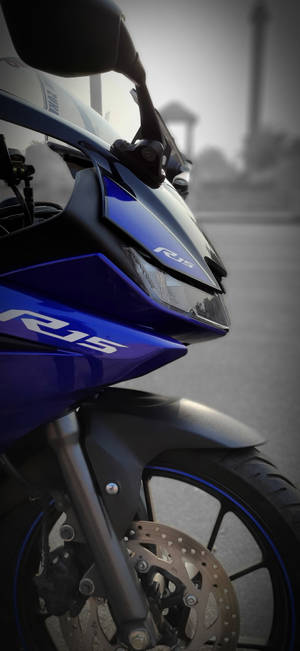 藍色Yamaha R15機車特寫，背景模糊的城市。 — Pixel 11 Pro 壁紙