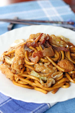 白色盤子中的雞肉培根蔬菜炒麵。 — 2:3 壁紙