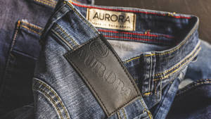 藍色牛仔褲的特寫，帶有品牌標誌的皮革標籤和可見縫線。 — 丹寧 壁紙