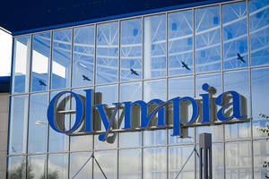 現代玻璃建築物，帶有藍色Olympia標誌和反射中飛翔的鳥兒。 — 標誌 壁紙