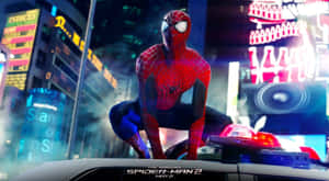蜘蛛人在夜晚的充滿活力的霓虹城市景觀中，棲息在一輛警車上。 — 蜘蛛人 壁紙