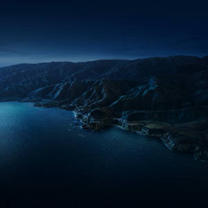 星空下的夜間海岸山路與深藍色海洋 — 美學 Mac 壁紙