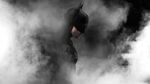 蝙蝠俠身穿深色服裝，從煙霧中出現，背景是星空。 — 死亡騎士 壁紙