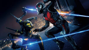 蟻人與黃蜂女在夜間城市上空進行一場高能量的戰鬥。 — 漫威復仇者聯盟 壁紙