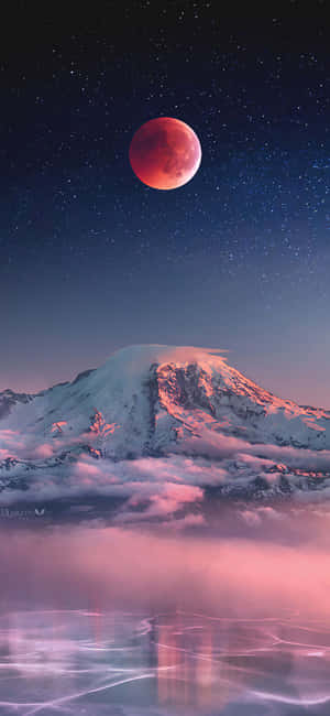 血月映照在積雪的山峰上，夜晚倒映在霧濛濛的山谷中。 — 月光 壁紙