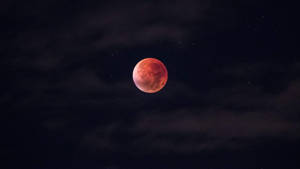 血月在烏雲中閃耀，點綴著星空的夜空。 — 高畫質月亮 壁紙