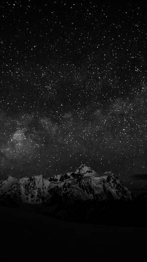 積雪的山峰在可見銀河的星空下。 — 暗色安卓 壁紙