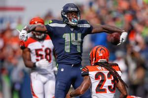西雅圖海鷹隊14號球員張開雙臂抱住橄欖球慶祝達陣。 — Dk Metcalf 壁紙