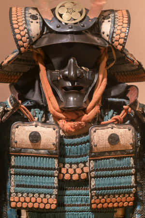 華麗的武士盔甲特寫，配有黑色面具和藍橙色繫帶。 — 小米18 Fold 壁紙