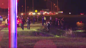 夜間路邊事故現場，警察和緊急人員伴隨閃爍燈光。 — 警察 GIF 壁紙