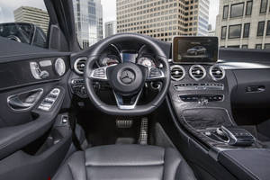 黑色皮革豪華汽車內裝，配木質飾邊及城市景觀。 — Mercedes Benz C300 壁紙