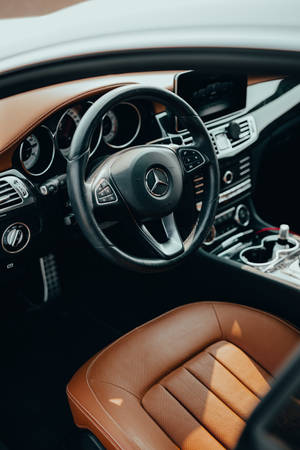 豪華車棕褐色皮革內裝和黑色方向盤的特寫。 — Mercedes Amg iPhone 壁紙