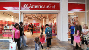 家庭和兒童在American Girl玩具店入口外。 — 可愛粉色女孩 壁紙