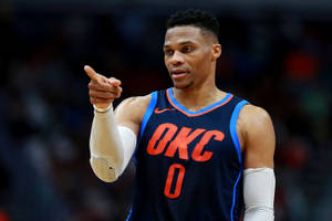身穿OKC球衣的籃球運動員在比賽中指。 — 羅素·衛斯特布魯克 壁紙