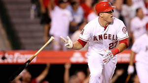 棒球選手在夜間比賽中慶祝全壘打。 — Mike Trout 壁紙