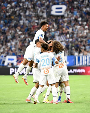 足球運動員在座無虛席的體育場內慶祝進球。 — 4:5 壁紙