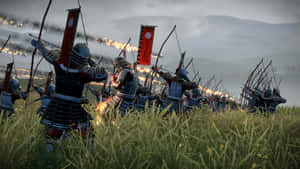 武士弓箭手在煙霧和火焰的戰場上射箭。 — 混沌武士 壁紙