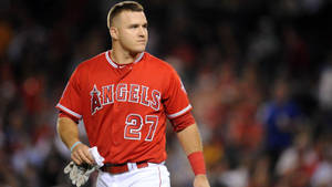 身穿紅色天使隊球衣的棒球運動員在夜間走在場地上。 — Mike Trout 壁紙