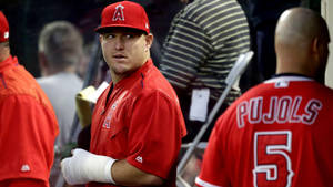 手上纏著石膏的棒球選手，在隊友普荷斯附近的休息區。 — Mike Trout 壁紙