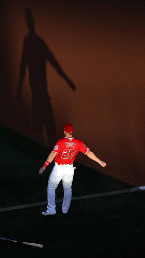 身穿紅色球衣的棒球運動員Mike Trout在夜間在牆上投下長長的陰影。 — Mike Trout 壁紙